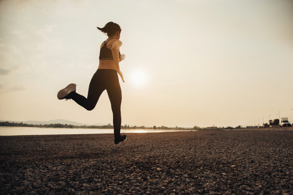 ผู้หญิงกำลังวิ่งอย่างรวดเร็ว สลับวิ่งเหยาะๆ ตามหลัก HIIT ซึ่งเป็นการคาร์ดิโออย่างรวดเร็วในช่วงสั้นๆ สลับกับคาร์ดิโอเบาๆ