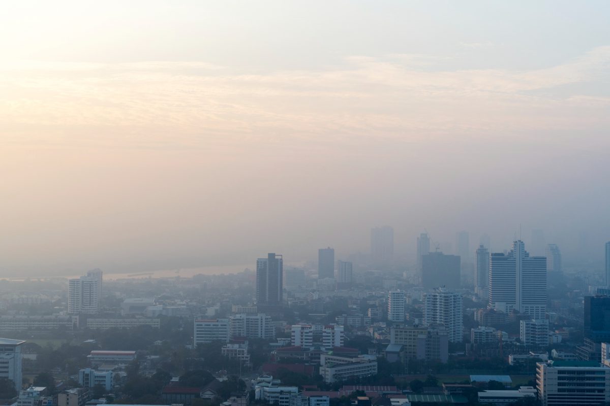 ภาพทิวทัศน์มุมสูงในเมืองที่พร่ามัวจากการปกคลุมของหมอกควันและฝุ่นพิษ PM 2.5